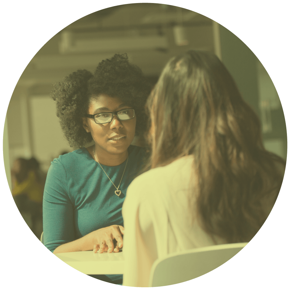 Two people talking at a desk